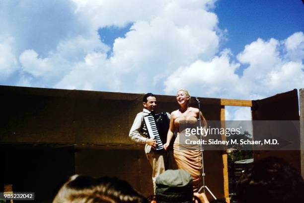 Accompanied by an accordionist, a unidentified singer performs on stage at the 8063rd MASH , South Korea, August 1952.