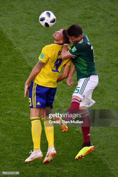 Hector Moreno of Mexico wins a header over Marcus Berg of Sweden during the 2018 FIFA World Cup Russia group F match between Mexico and Sweden at...