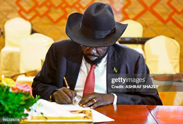 Salva Kiir prisedent of south sudan signs documents after the two South Sudanese arch-foes agreed in Khartoum on June 27 to a "permanent" ceasefire...