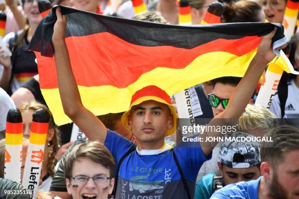 Supporter of the German national football team waves a German flag as he attends a public viewing event at the Fanmeile in Berlin to watch the Russia...