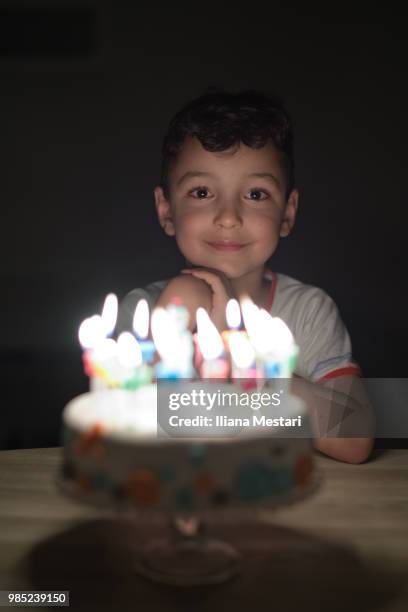 5 y old boy blowing candles on a cake - iliana mestari stock pictures, royalty-free photos & images