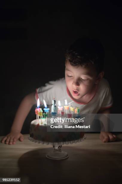 5 y old boy blowing candles on a cake - iliana mestari stock pictures, royalty-free photos & images
