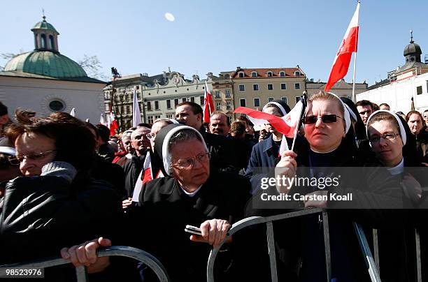 Women follow as the coffins of late Polish President Lech Kazcynski and his wife Maria arrive at the St Mary's Basilica on April 18, 2010 in Krakow,...