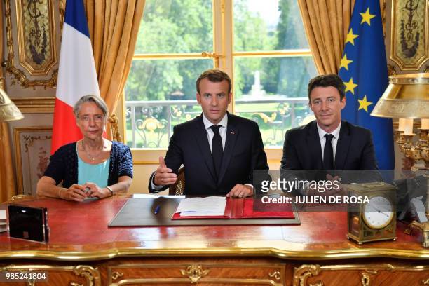 French President Emmanuel Macron , flanked by French Transports Minister Elisabeth Borne and French government spokesman Benjamin Griveaux, speaks to...