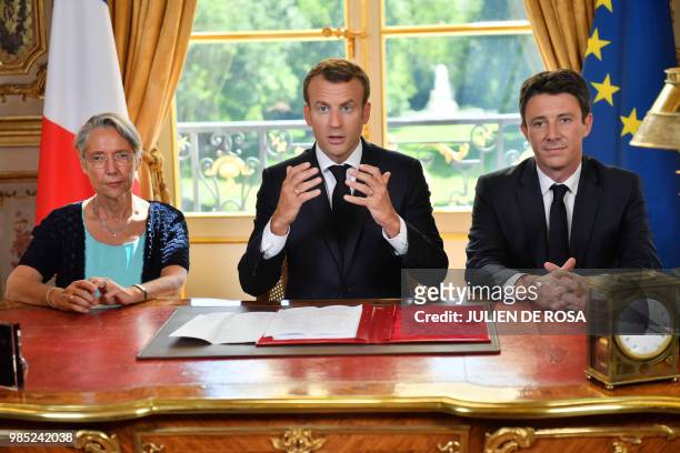 French President Emmanuel Macron , flanked by French Transports Minister Elisabeth Borne and French government spokesman Benjamin Griveaux, speaks to...