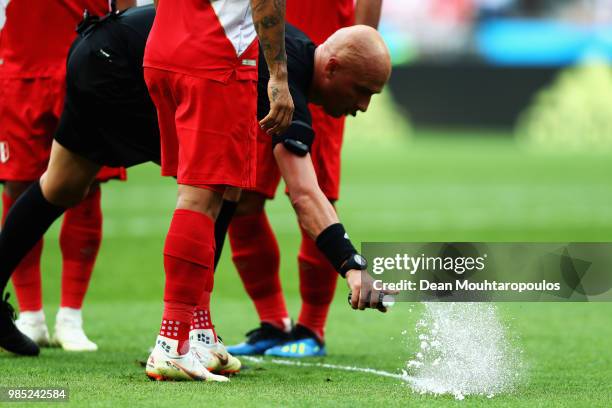 Referee, Sergei Karasev marks the defensive wall line with vanishing spray or foam during the 2018 FIFA World Cup Russia group C match between...