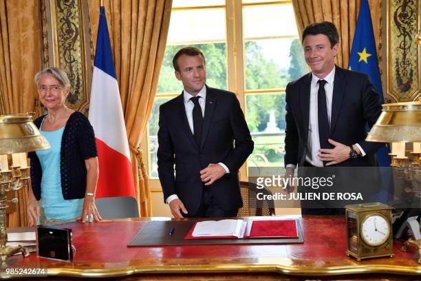 French President Emmanuel Macron , flanked by French Transports Minister Elisabeth Borne and French government spokesman Benjamin Griveaux, leaves...