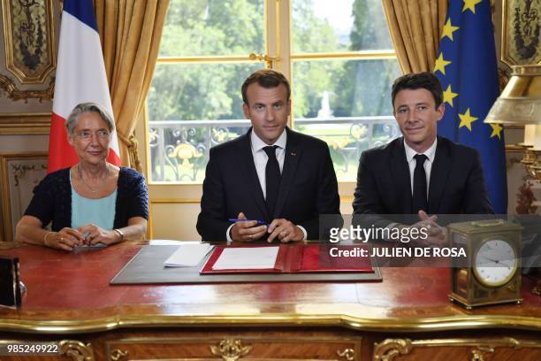French President Emmanuel Macron , flanked by French Transports Minister Elisabeth Borne and French government spokesman Benjamin Griveaux, looks on...