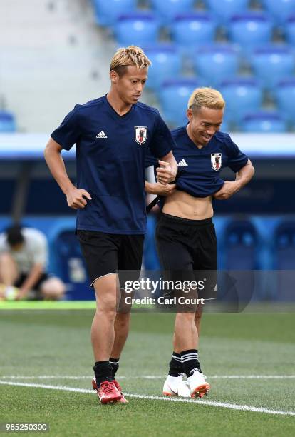 Keisuke Honda of Japan speaks with Yuto Nagatomo of Japan during a Japan training session ahead of the FIFA World Cup Group H match between Poland...