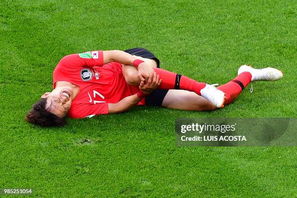 South Korea's midfielder Lee Jae-sung reacts in pain during the Russia 2018 World Cup Group F football match between South Korea and Germany at the...