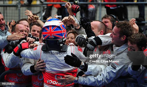 Jenson Button of Great Britain and McLaren Mercedes celebrates in parc ferme with team mates and girlfriend Jessica Michibata after winning the...