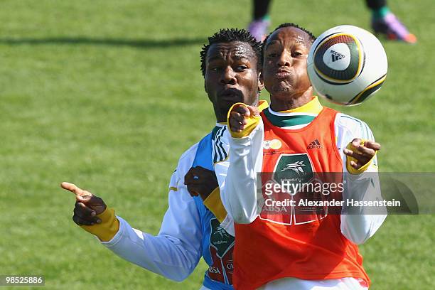Bongani Khumalo of the South African national football team challenges for the ball with his team mate Lucas Thwala during a training session of the...
