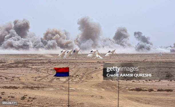 Smoke billow as Pakistani army tanks and gunship helicopters hit their targets during a military exercise in Bahawalpur on April 18, 2010. The...