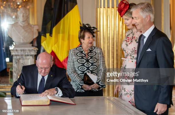 Sir Peter Cosgrove, Governor General of the Commonwealth of Australia signs the Guest Book as H.E. Lady Cosgrove, Queen Mathilde and King Philip of...