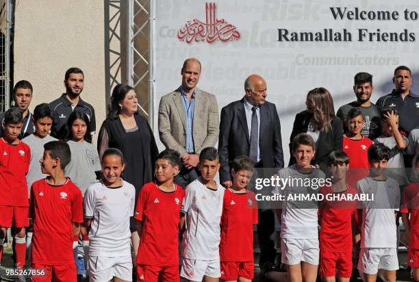 Head of the Palestinian Football Federation, Jibril Rajoub and Britain's Prince William pose for a picture with young Palestinian football players in...