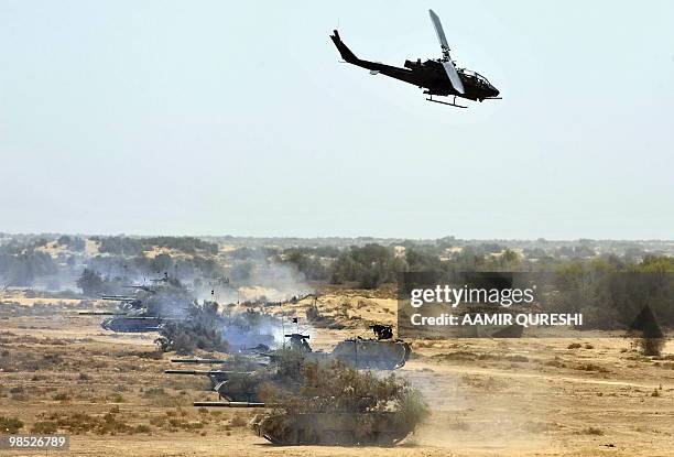 Pakistani Army AH-1 Cobra attack helicopter returns after hitting its target as military tanks advance on the ground as they take part in a military...
