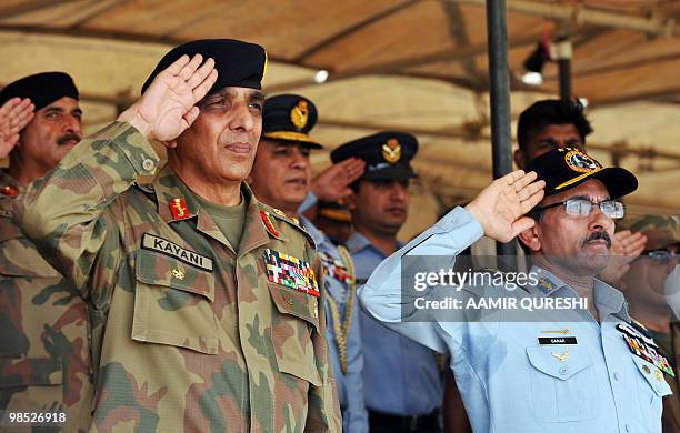Pakistani Army Chief General Ashfaq Kayani and Air Force Chief Marshal Rao Qamar Suleman salute during the national anthem as they arrive to witness...
