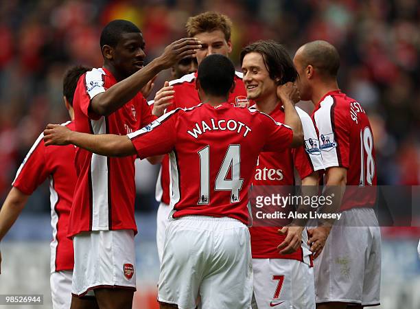 Theo Walcott of Arsenal celebrates with team mates after scoring the opening goal during the Barclays Premier League match between Wigan Athletic and...