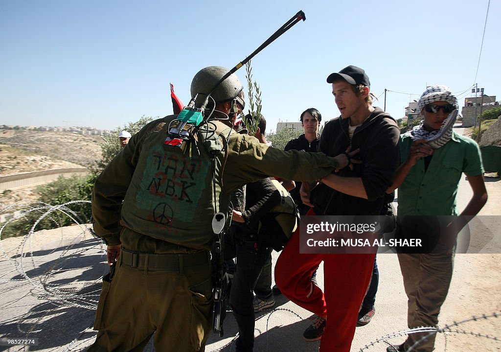 Israeli soldiers stop protesters from ad