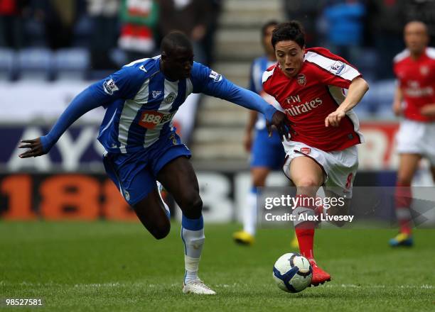 Samir Nasri of Arsenal holds off a challenge from Steve Gohouri of Wigan Athletic during the Barclays Premier League match between Wigan Athletic and...