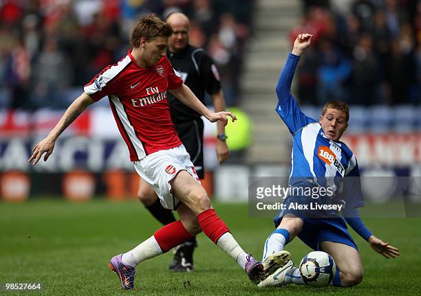 Nicklas Bendtner of Arsenal is tackled by James McCarthy of Wigan Athletic during the Barclays Premier League match between Wigan Athletic and...
