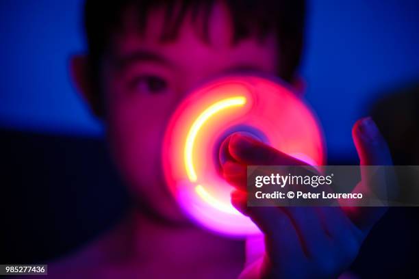 young boy playing with fidget spinner - fidget spinner stock-fotos und bilder