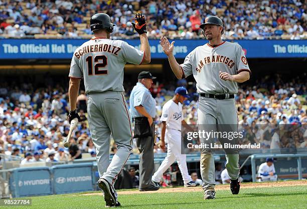 Aubrey Huff celebrates with teammate Nate Schierholtz of the San Francisco Giants after scoring in the fourth inning against the Los Angeles Dodgers...