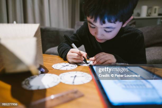 boy crafting a clock tower out of cardboard - peter lourenco stock-fotos und bilder