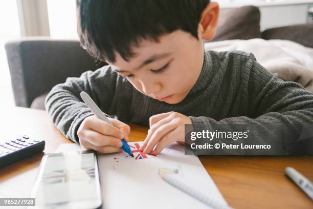 boy crafting a clock tower out of cardboard - peter lourenco stock-fotos und bilder