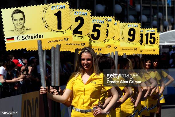 Grid girls hold up signs with the names of this year's drivers during the presentation of the German Touring Car Championship DTM in front of the...