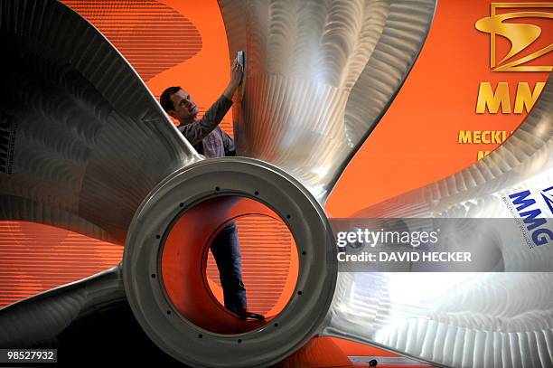 An exhibition worker polishes a six-metre-big ship propeller by the company MMG on the fair grounds in Hanover, northern Germany, in preparation of...