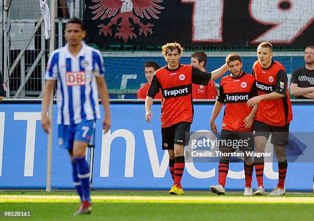 Uemit Korkmaz celebrates after scoring his team's first goal with team mates Alexander Meier and Halil Altintop during the Bundesliga match between...