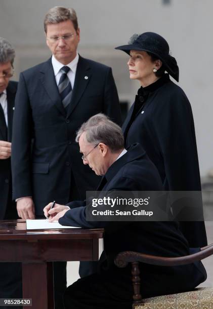 German President Horst Koehler signs a book of condolences as his wife Eva Luise Koehler and German Foreign Minister Guido Westerwelle look on at the...