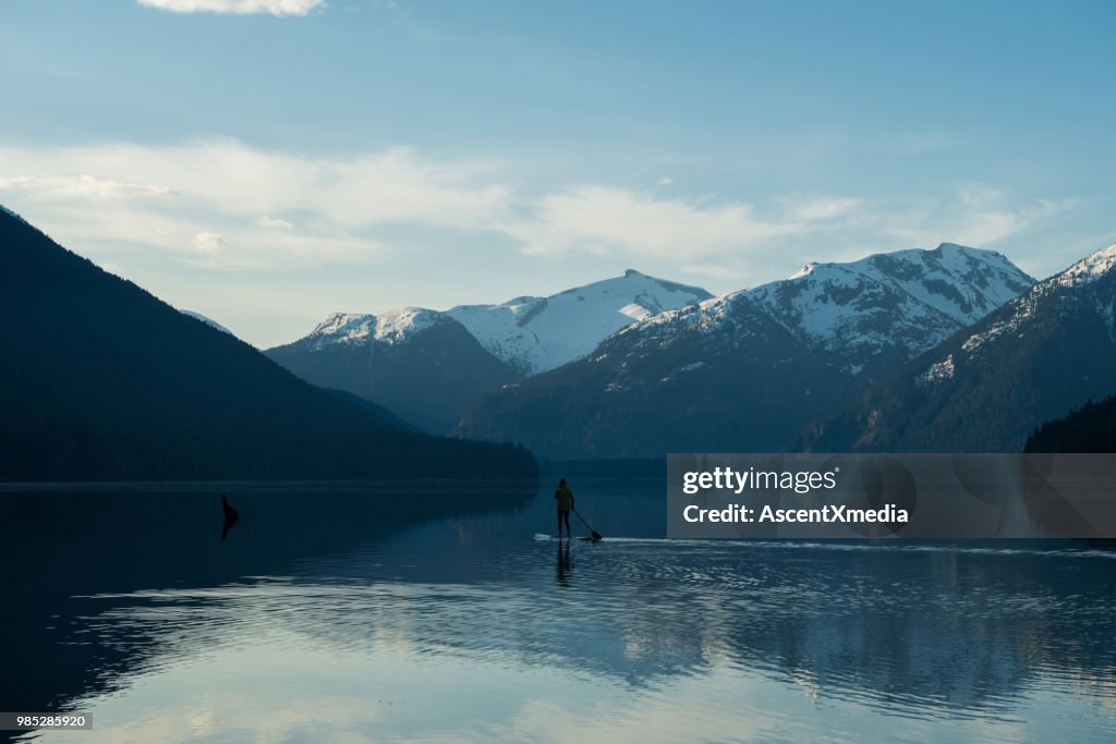 Vrouw peddelen op een prachtig bergmeer