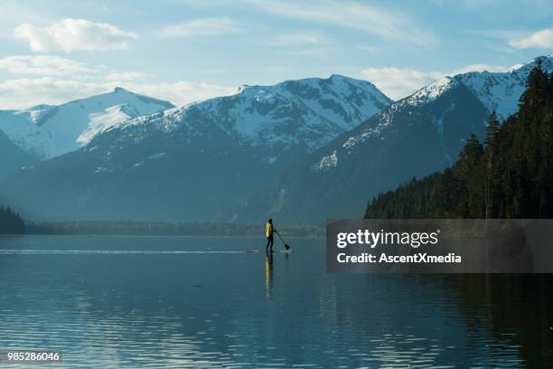 woman paddling on a stunning mountain lake - british columbia coast mountains stock pictures, royalty-free photos & images