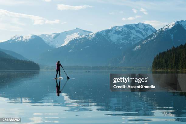 woman paddling on a stunning mountain lake - british columbia coast mountains stock pictures, royalty-free photos & images