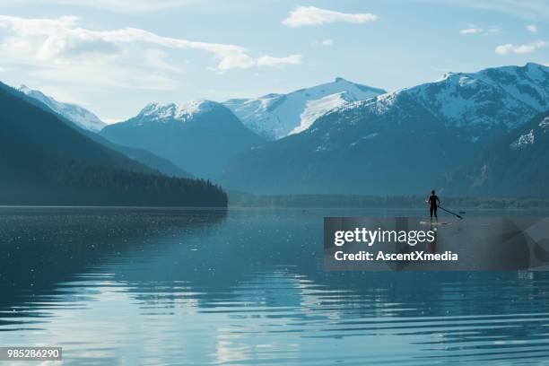 woman paddling on a stunning mountain lake - british columbia coast mountains stock pictures, royalty-free photos & images