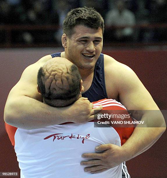 Turkish Riza Kayaalp is congratulated by his coach after winning gold against Serbian Radomir Petkovic during men's Free Style Wrestling 120 kg event...