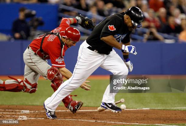 Vernon Wells of the Toronto Blue Jays scrambles to first while Jeff Mathis of the Los Angeles Angels of Anaheim grabs the ball during a MLB game at...