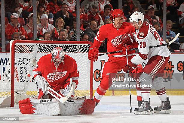 Jimmy Howard of the Detroit Red Wings makes a save as teammate Jonathan Ericsson ties up Lauri Korpikoski of the Phoenix Coyotes during Game Three of...