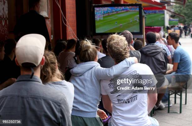 German team fans watch Germany play South Korea in the teams' World Cup match on the sidewalk outside a late night shop on June 27, 2018 in Berlin,...