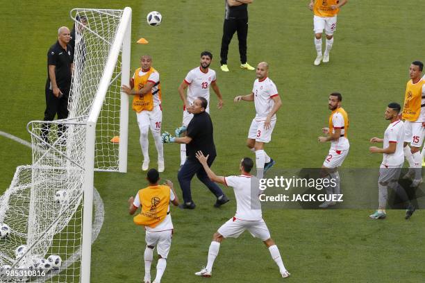 Tunisia's coach Nabil Maaloul trains as a goalkeeper with Tunisia's forward Wahbi Khazri , Tunisia's defender Yohan Benalouane , Tunisia's defender...