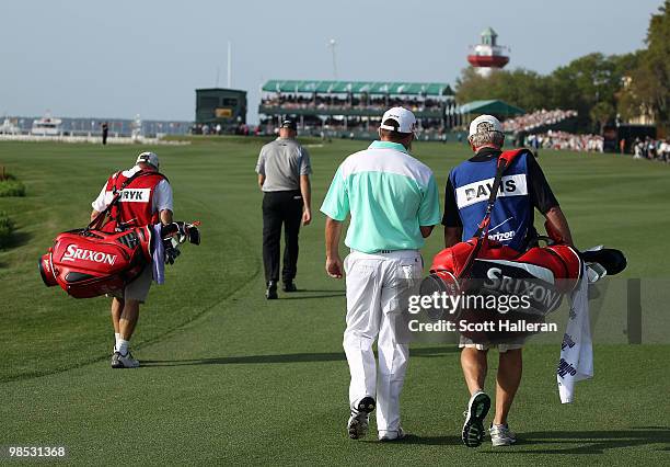 Jim Furyk and Brian Davis of England walk off the 18th tee with their caddies on the first playoff hole during the final round of the Verizon...