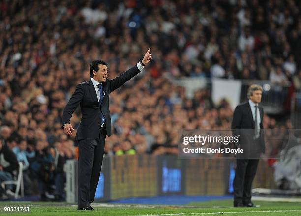 Valencia's manager Unay Emery instructs his team from the sideline beside Real Madrid manager Manuel Pellegrini during the La Liga match between Real...