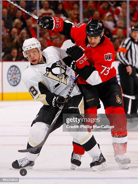 Kris Letang of the Pittsburgh Penguins dumps the puck in deep while Jarkko Ruutu of the Ottawa Senators tries to check him during Game 3 of the...