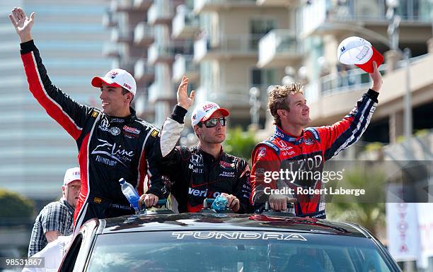 Justin Wilson of England Will Power of Australia and Ryan Hunter-Reay take a lap of honur and wave at the crowd during the IndyCar Series Toyota...