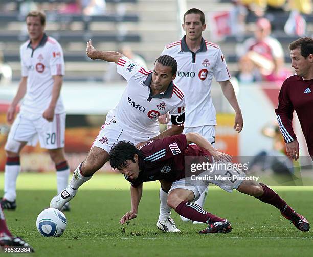 Kosuke Kimura of the Colorado Rapids battles Dwayne De Rosario of Toronto FC for a loose ball during the first half at Dick's Sporting Goods Park on...