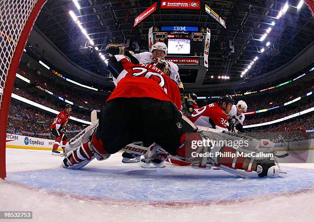 Sidney Crosby of the Pittsburgh Penguins cuts across the top of the net looking to put a shot past a sprawling Brian Elliott of the Ottawa Senators...