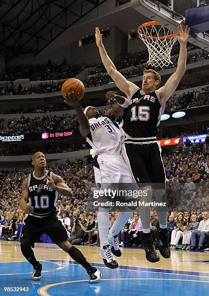 Guard Jason Terry of the Dallas Mavericks takes a shot against Matt Bonner and Keith Bogans of the San Antonio Spurs in Game One of the Western...