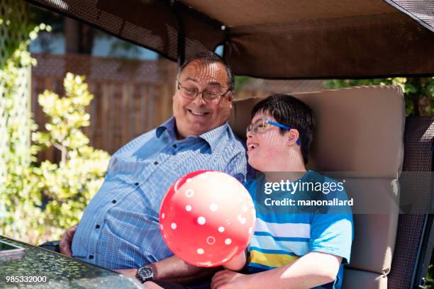 opa en kleinzoon van 12-jarigen met autisme en het syndroom van down in dagelijks leven - 11 12 years stockfoto's en -beelden